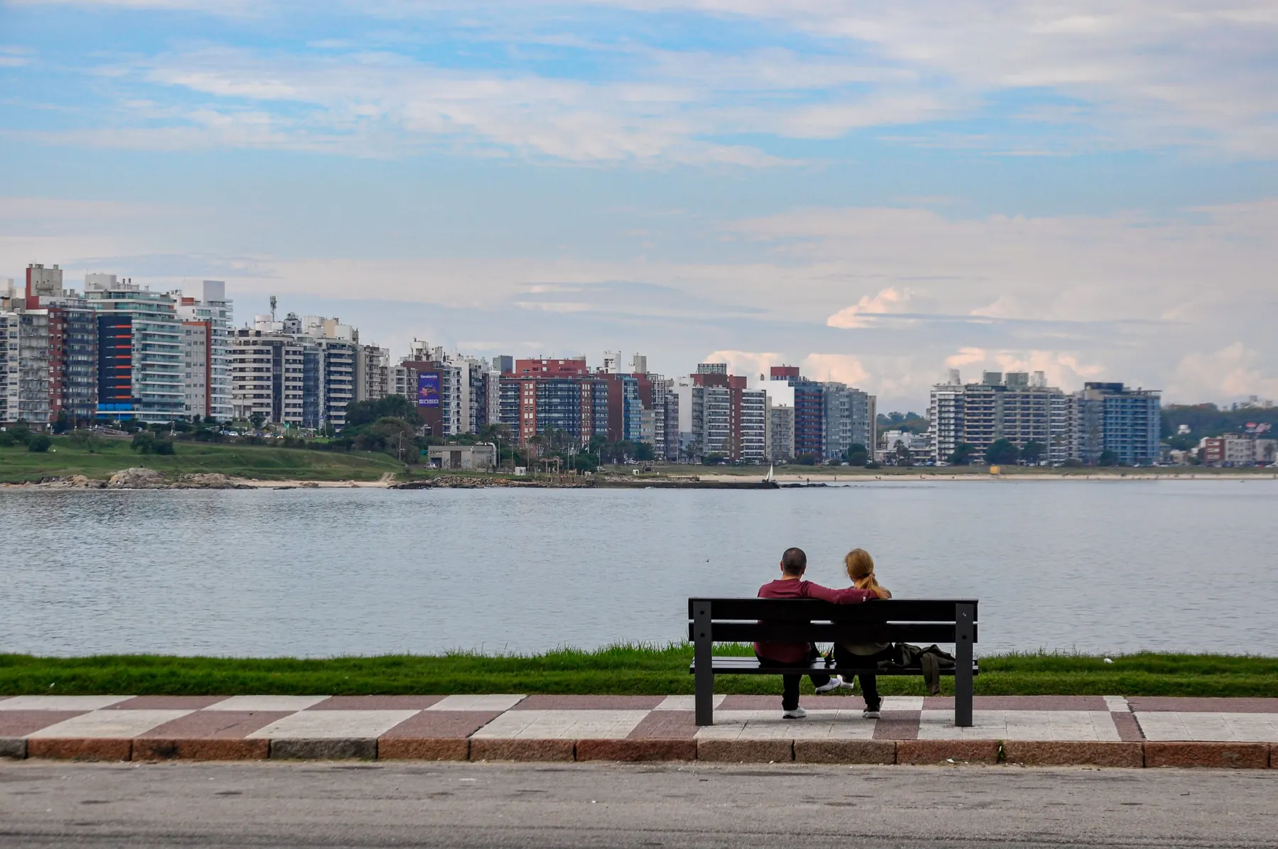 Una pareja en un banco mirando la ciudad desde la rambla